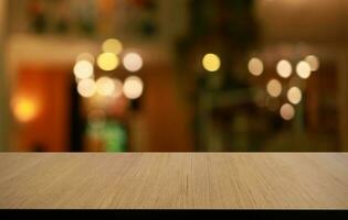 Empty wooden table in front of abstract blurred background of coffee shop . can be used for display or montage your products.Mock up for display of product photo