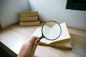 Books and a magnifier Research concept. Magnification glass over a opened book. photo