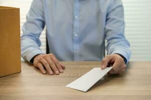 sending resignation letter to boss and Holding Stuff Resign Depress or carrying cardboard box by desk in office photo