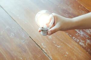 Idea of business person holding light bulb concept creativity with bulbs. photo