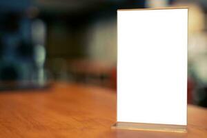 Mock up Menu frame standing on wood table in Bar restaurant cafe. space for text photo