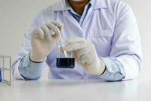 Science innovative Male medical or scientific laboratory researcher performs tests with blue liquid in laboratory. equipment science experiments technology Coronavirus Covid-19 vaccine research photo