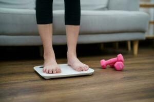 Fat diet and scale feet standing on electronic scales for weight control. Measurement instrument in kilogram for a diet control photo