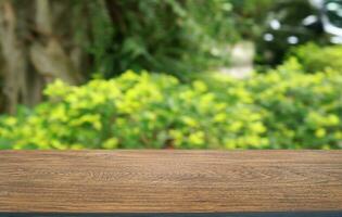 vacío madera mesa parte superior y difuminar de fuera puerta jardín antecedentes vacío de madera mesa espacio para texto márketing promoción. blanco madera mesa Copiar espacio foto
