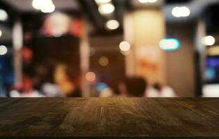 Empty dark wooden table in front of abstract blurred bokeh background of restaurant . can be used for display or montage your products.Mock up for space. photo