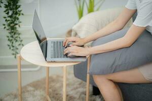 Working by using a laptop computer on wooden table. Hands typing on a keyboard.technology e-commerce concept photo