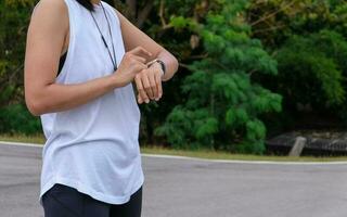 woman measuring smart watch with heart rate after running, health apps concept. photo