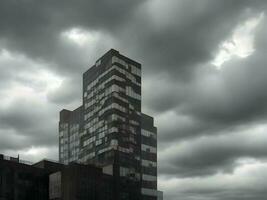 un Clásico antiguo edificio con oscuro nubes en el cielo, ai generación. foto