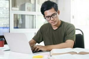 Young collage student using computer and mobile device studying online. photo