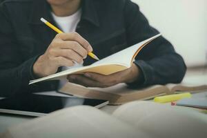 cerca arriba manos con bolígrafo escritura en cuaderno. foto