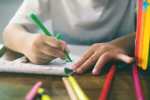 Kindergarten boy drawing and learning at home. photo