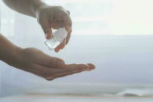 Close up man hands using wash hand sanitizer gel dispenser. photo