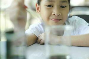 Little child with learning science class in school laboratory photo