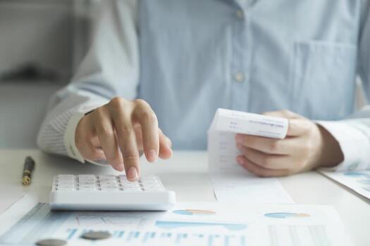 Accountant using calculator for calculate finance report in office photo
