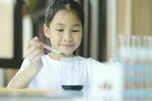 Little child with learning science class in school laboratory photo