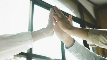 Shot of a group of colleagues giving each other a high five. photo