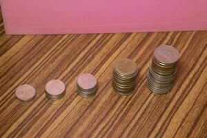 Stacking coins on the wooden table and growth graph to save money or investment to get business income by finance  marketing photo