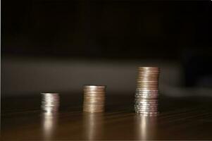 Stacking coins on the wooden table and growth graph to save money or investment to get business income by finance  marketing photo