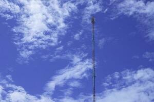 telephone signal tall pole  on blue clear sky background photo