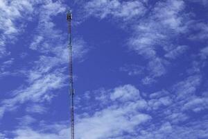 telephone signal tall pole  on blue clear sky background photo