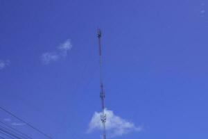 telephone signal tall pole  on blue clear sky background photo