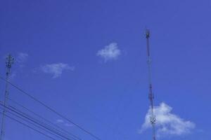 telephone signal tall pole  on blue clear sky background photo