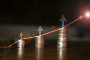 Stacking coins on the wooden table and growth graph line chart target to save money or investment of business concept income by finance  marketing photo