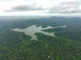 aéreo ver de el reservorio Entre el montañas y bosque. foto