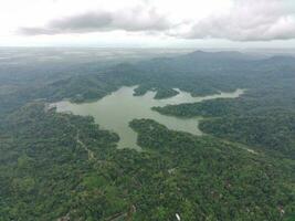 aéreo ver de el reservorio Entre el montañas y bosque. foto