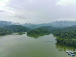 Aerial view of the reservoir between the mountains and forest. photo