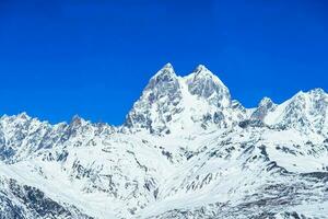 hermosa panorámico ver ushba pico en Cáucaso montañas cubierto con nieve en invierno y azul cielo en mestia svaneti Georgia foto