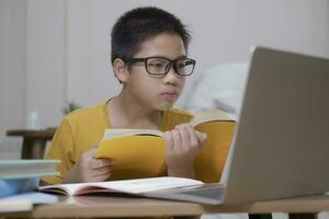 Young collage student using computer and mobile device studying online. photo