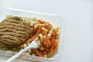 Delicious breakfast in a container. Breakfast with vermicelli fried cutlet and vegetables. photo