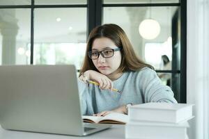 Young collage student using computer and mobile device studying online. photo