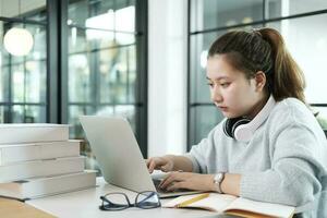 Young collage student using computer and mobile device studying online. photo
