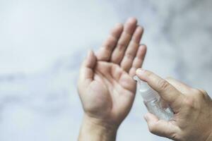 Close up man hands using wash hand sanitizer gel dispenser. photo