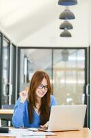 A female college student uses a computer to access the Internet for online learning. photo