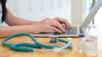 Doctor sitting at workplace and using laptop. photo