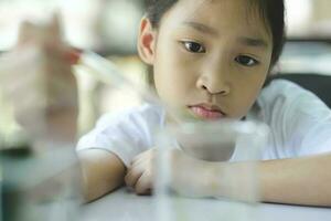 pequeño niño con aprendizaje Ciencias clase en colegio laboratorio foto