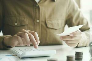 Accountant using calculator for calculate finance report in office. photo