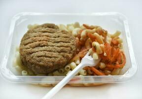 Delicious breakfast in a container. Breakfast with vermicelli fried cutlet and vegetables. photo