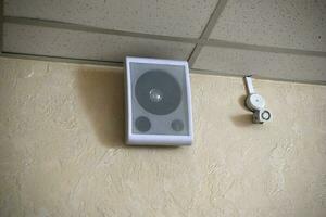 A fire sensor on the ceiling and a sound speaker. photo