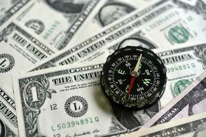 Compass and banknotes. US dollars. Navigation in the financial world. photo