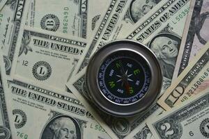 Compass and banknotes. US dollars. Navigation in the financial world. photo