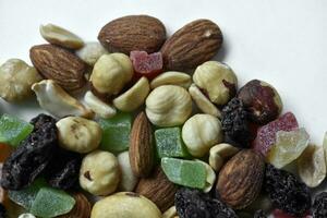 Nut mixture on a white background. A delicious snack of nuts and dried fruits. photo