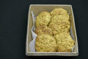 Shortbread cookies in a cardboard box on a black background. Delicious cookies in a box. Oatmeal cookies. photo