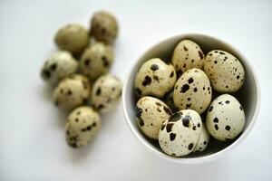 Quail eggs in a white plate. Food eggs on a white background. photo