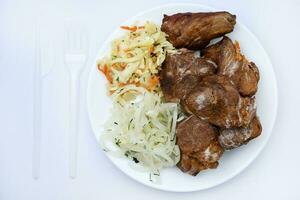 Beautiful fried pieces of pork meat. Pork kebab with vegetables. Meat on a plate. photo