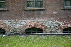 Basement windows of an old house and a green lawn. The basement of an old house. photo