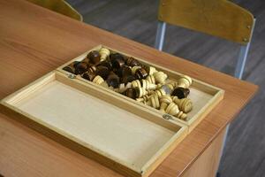 The chessboard is on the table. Chess pieces in the board. Chess set. photo